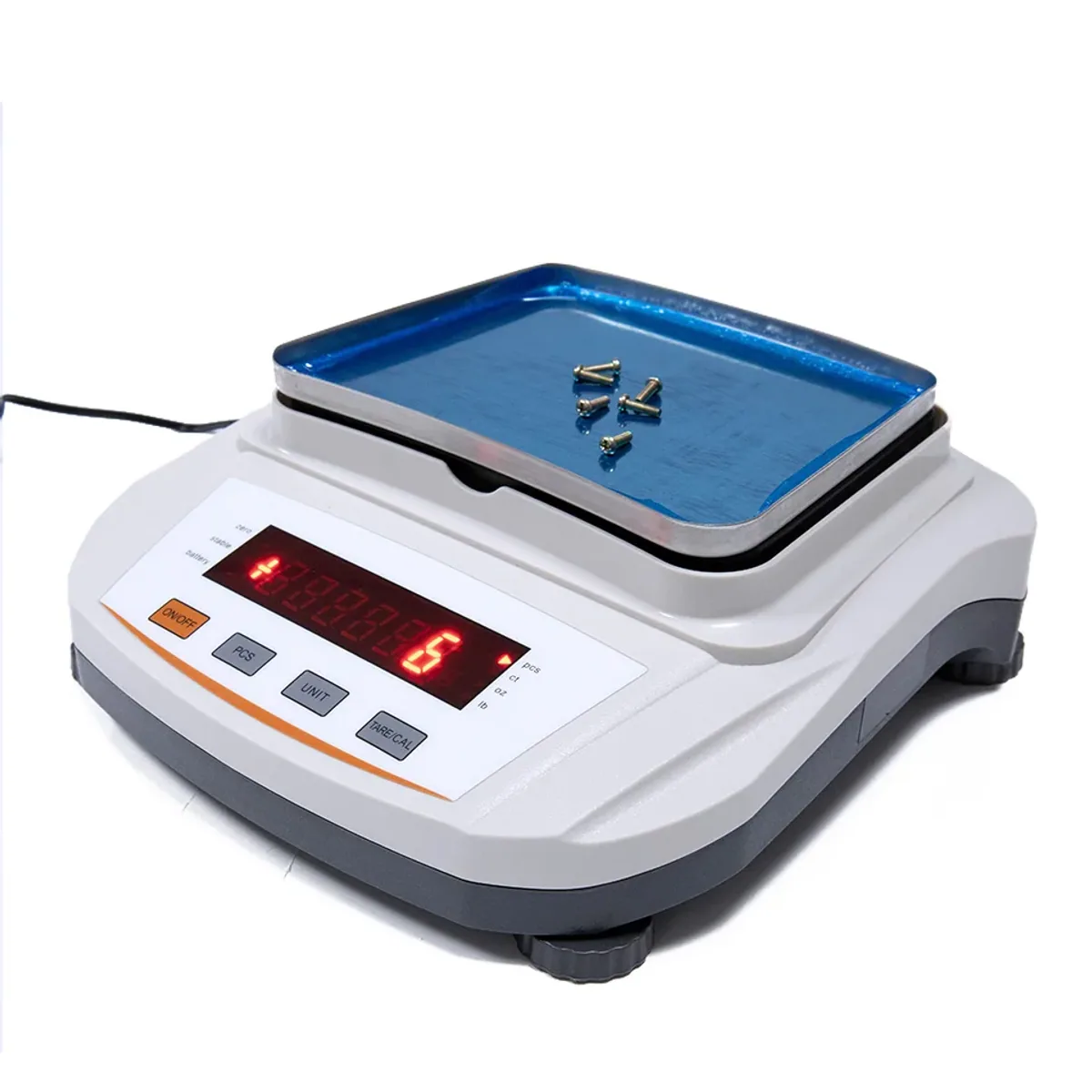 Digital precision balance with a stainless steel pan holding small screws, with the LED display and buttons visible