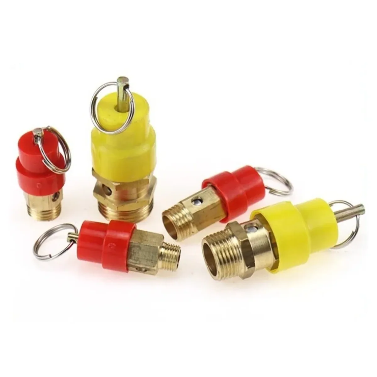 Five brass pressure relief valves with red and yellow plastic caps and pull rings laid out together